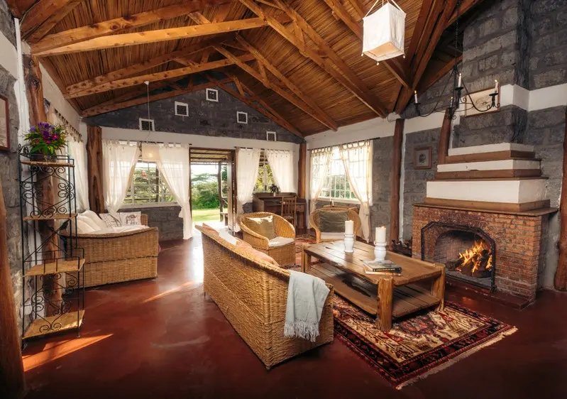 The fire lit in the Family Villa lounge, rugs on the floor and the garden through the open doors