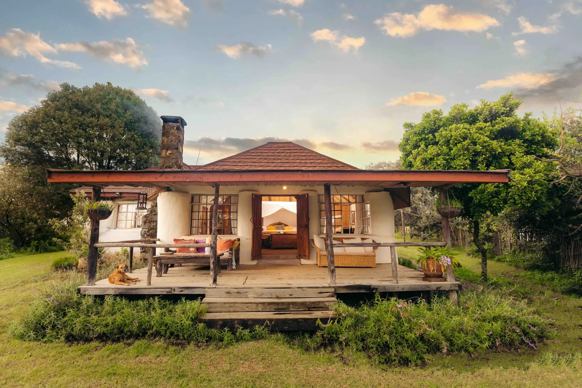 The Romantic Cottage and its verandah on a lawn above Lake Naivasha, in the evening light