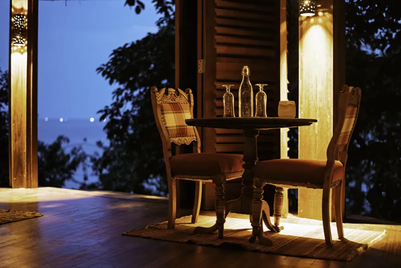A lamplit table for two on the terrace above Lake Tanganyika at dusk