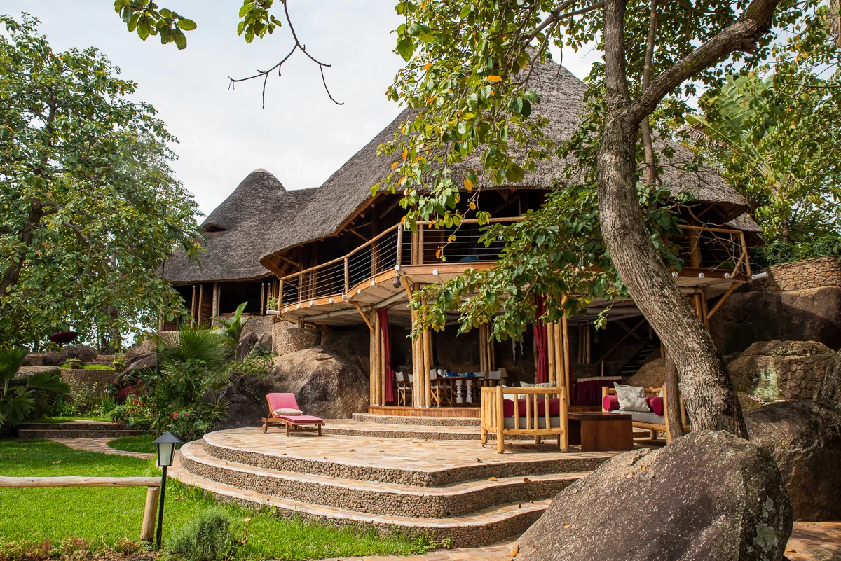 The twin-peaked thatched Moonstone villa with its open lounge terrace, curved stone steps and sun lounger on the lawn