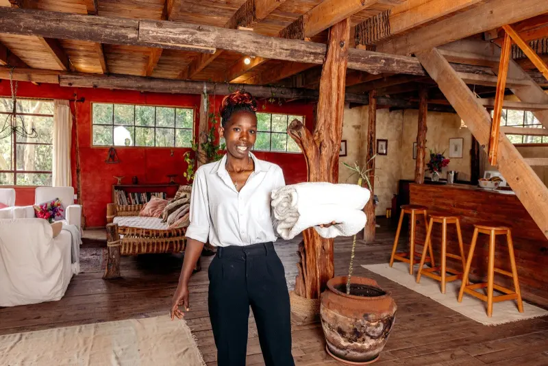 A member of the Malu team welcoming guests in a timber-framed room